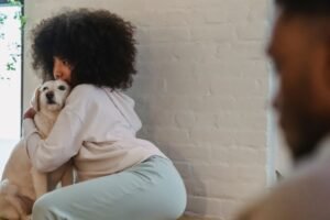 A person comforting their dog with a hug — finding solace after losing a pet