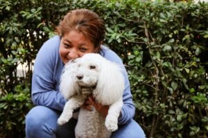 Happy dog mom embracing her dog — the perfect recipient for a thoughtful pet lover gift